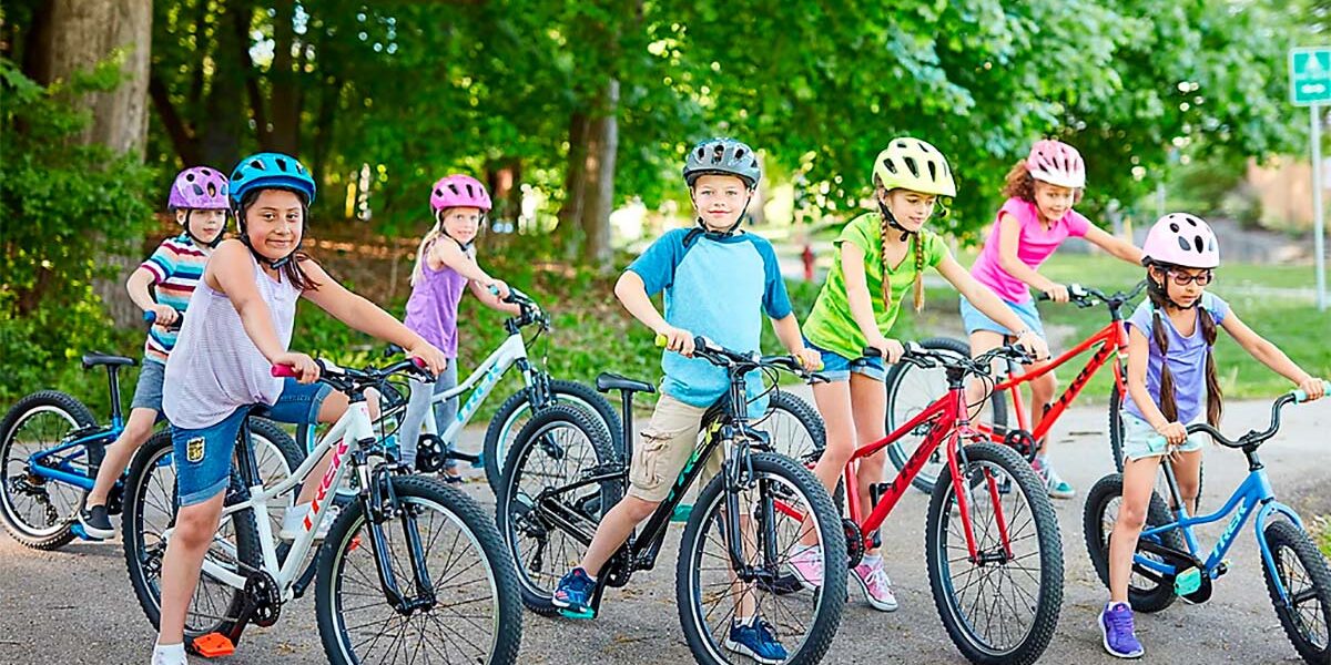 Dos Niña En Bicicleta. Chicas Con Casco De Ciclista Y La Bicicleta